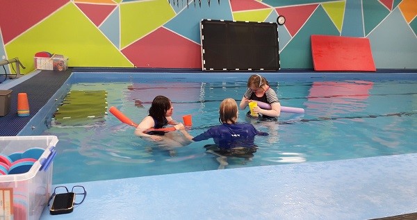 three people in a swimming pool