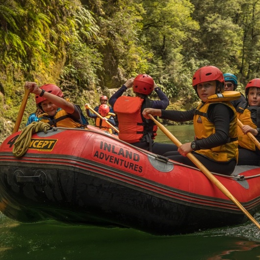 Group of rangatahi paddling along a river image