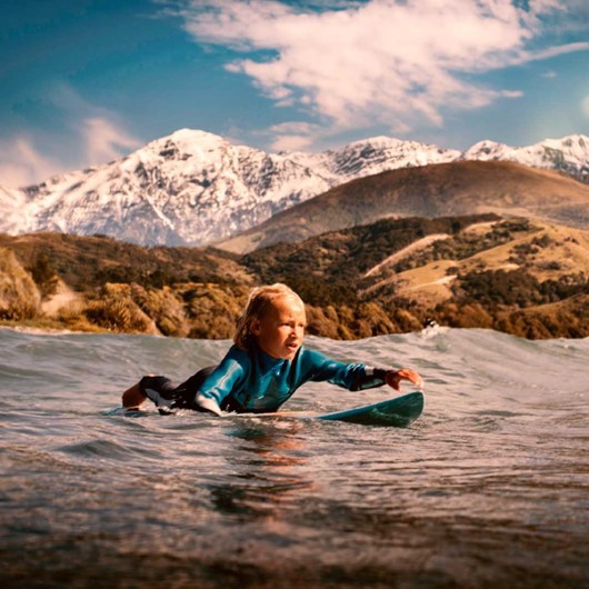 Tamariki Paddles Surfboard Out To The Incoming Set image