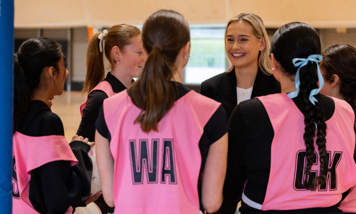 Coach Tayla in a huddle with her team