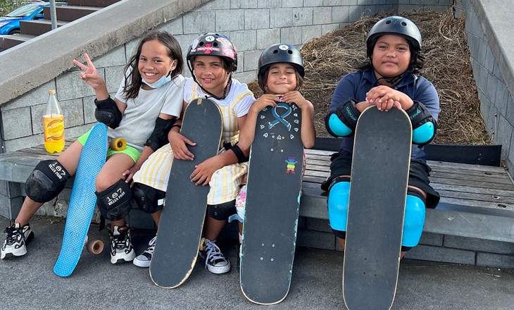 Four tamariki holding skateboards