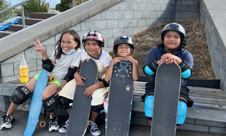 Four tamariki holding skateboards