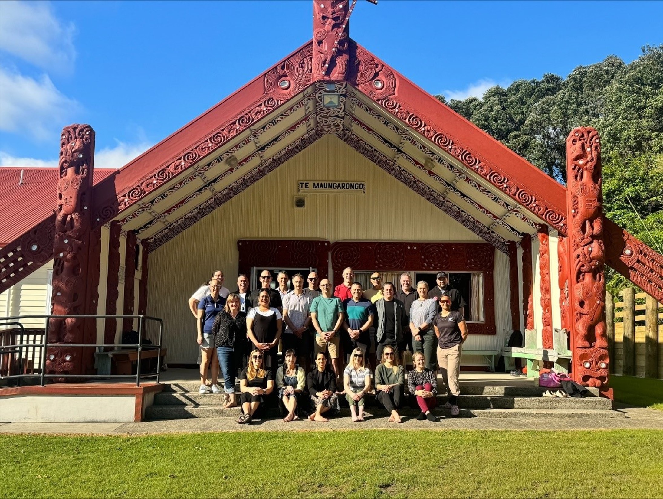 Group of people standing in front of a marae