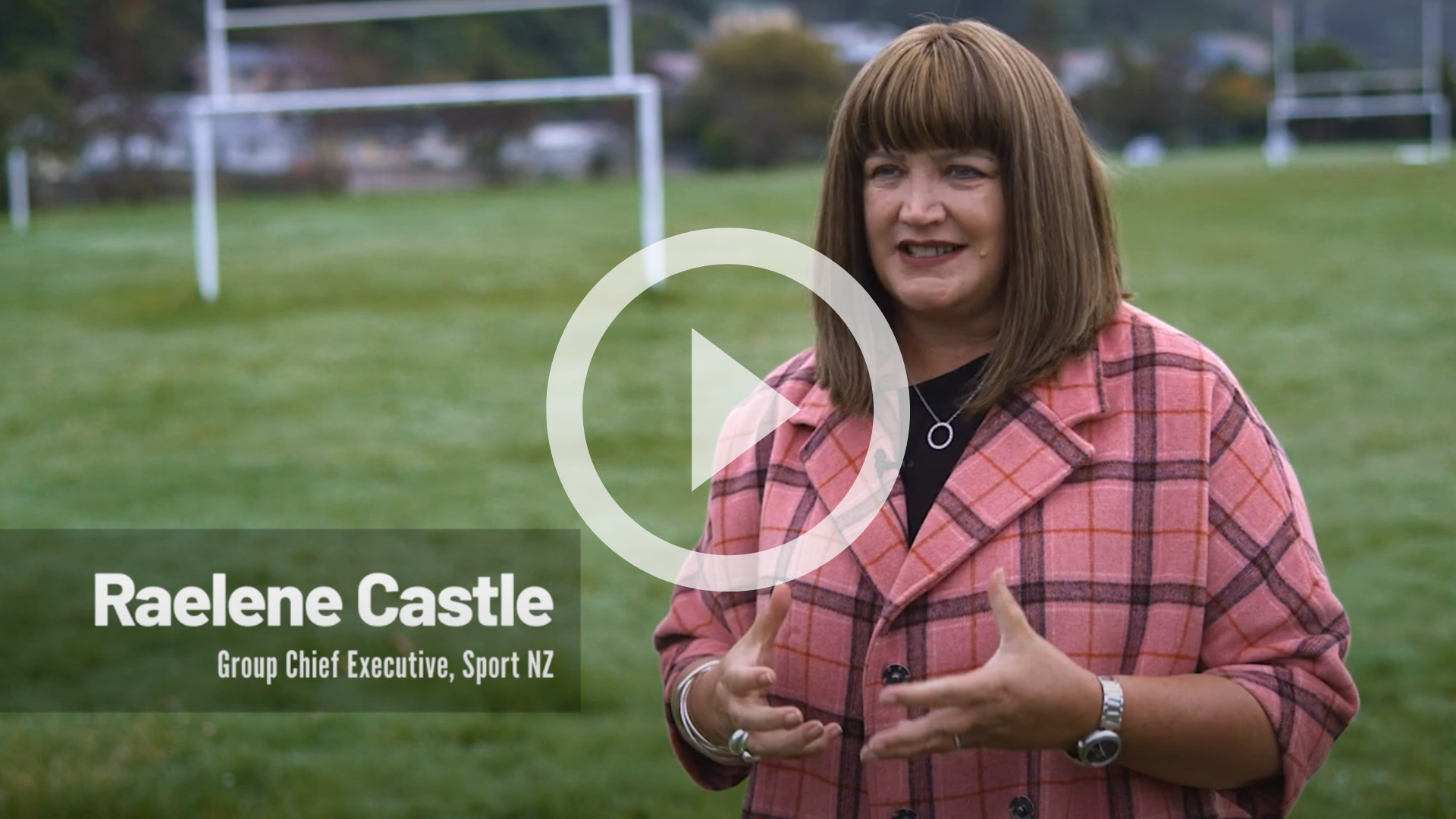 Raelene Castle on a rugby field talking to a camera