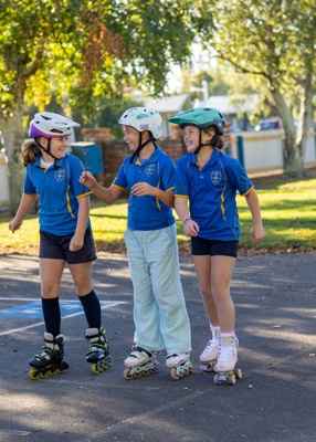 Three tamariki rollerblading
