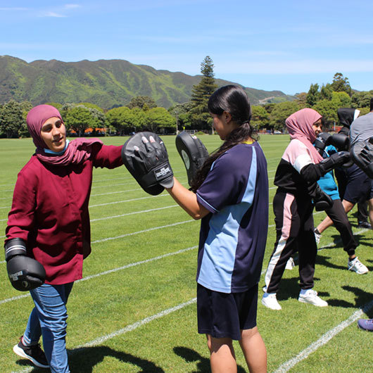 Rangatahi wahine boxing training on an athletics field image