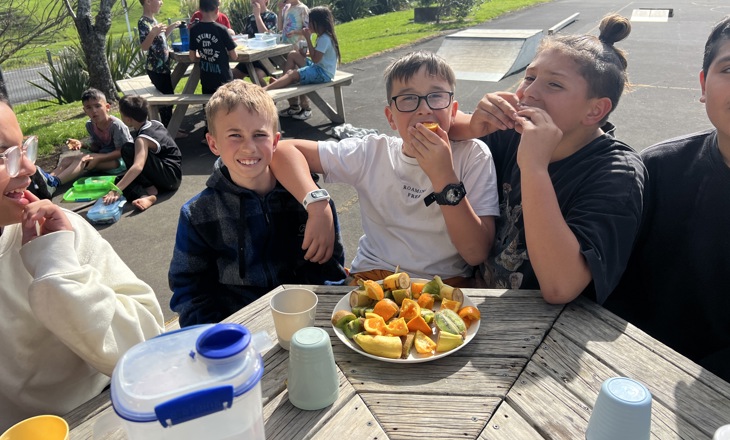School kids eating food on benches outside