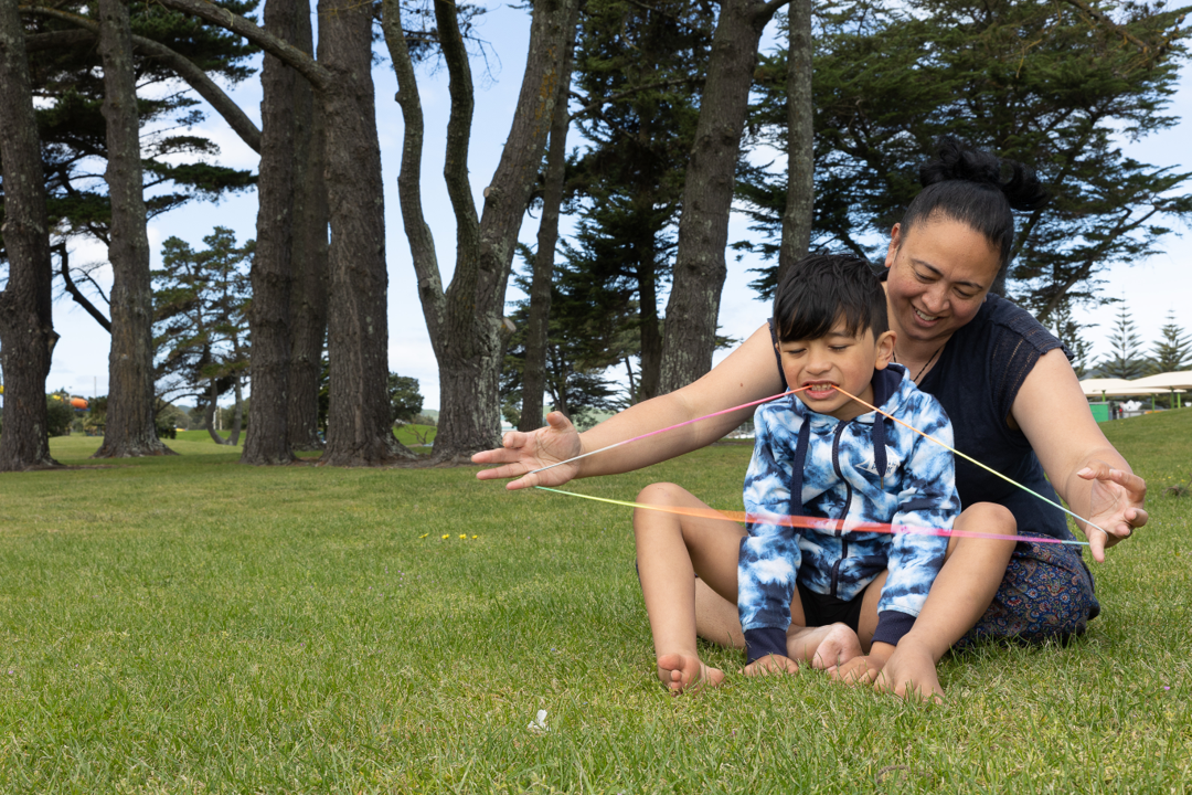 Mother and son on a field playing string games