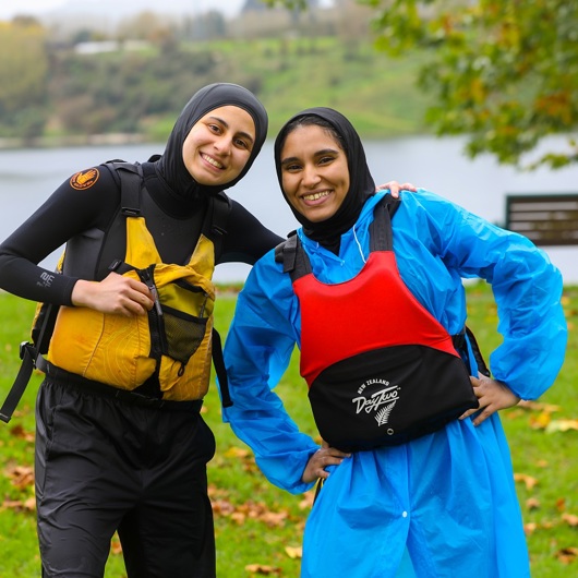Two young women smiling to camera wearing lifejackets