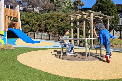 Lorna Irene Reserve Playground with two tamariki playing on it