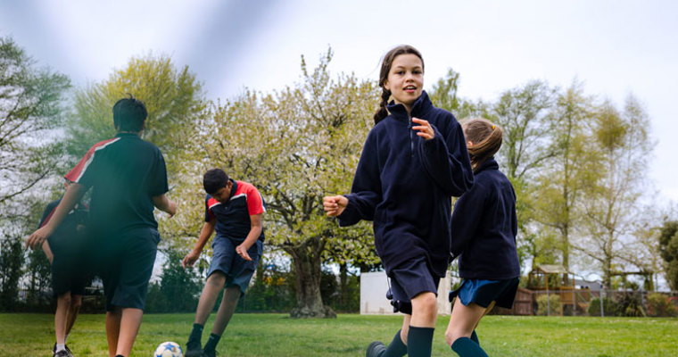 Students playing football in a park