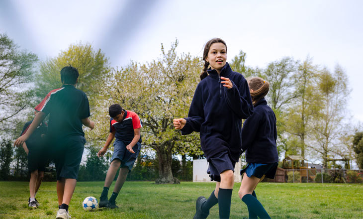 Students playing football in a park