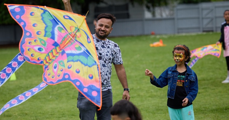 Kids playing with a butterfly shaped kite