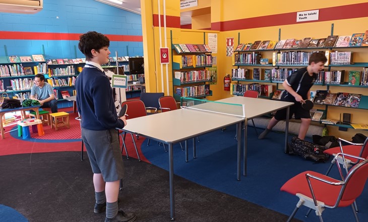 Tamariki playing ping pong in a library