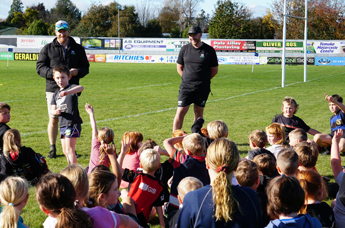 Students sitting behind a try line talking with teachers