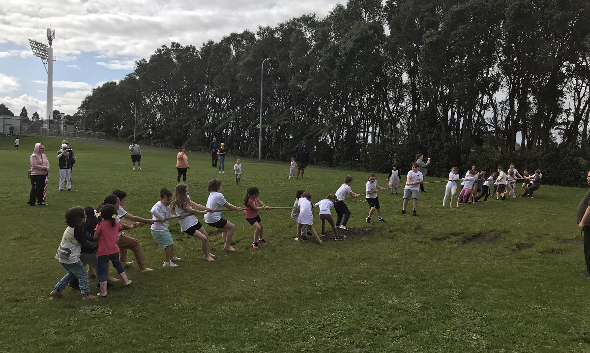Children playing tug of war on a field