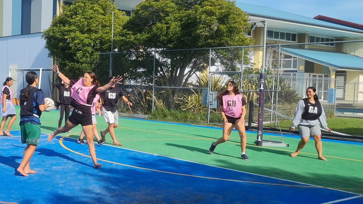Young people playing netball on a court