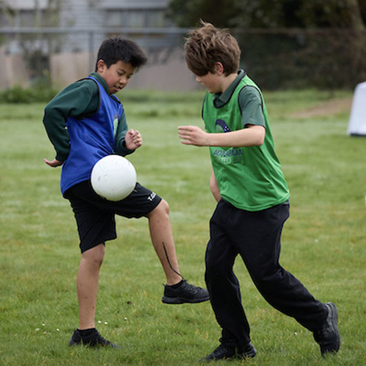 Two boys playing with a soccer ball image