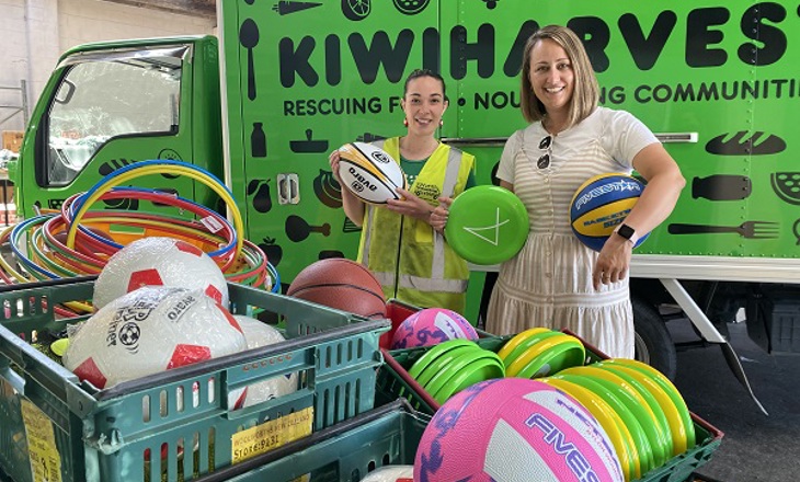 Two women standing behind a box of play equipment