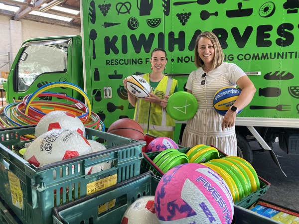 Two women standing behind a box of play equipment
