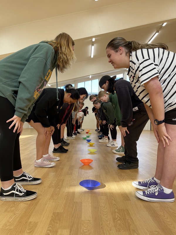 young people doing sport drills in a hall