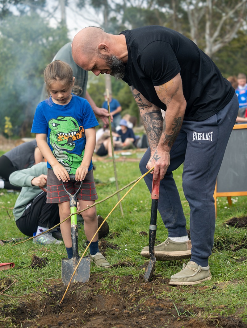 Father and daughter using shovels to dig in dirt
