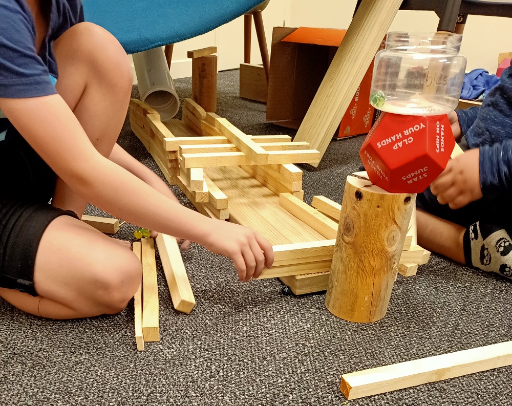 Tamariki playing with blocks and other spare toys