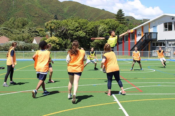 young people playing basketball outside