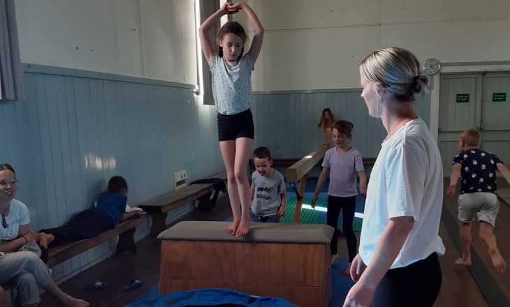 Tamariki practicing vault in a school gym